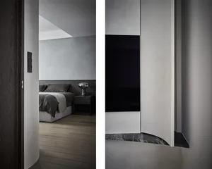 Minimalistic bedroom with gray furniture and wooden flooring.