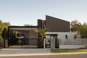 A modern house exterior featuring wood paneling, concrete walls, and metal accents.