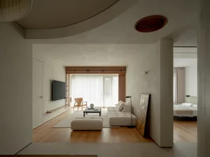 Modern living room with minimalist design, neutral tones, and a combination of light wood, white, and beige elements.