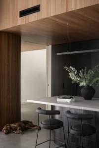 Modern kitchen interior featuring a concrete countertop, wooden cabinets, and a metal faucet.