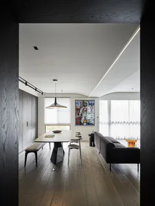 A modern living and dining space featuring hardwood flooring, minimalistic design, and sleek furniture.