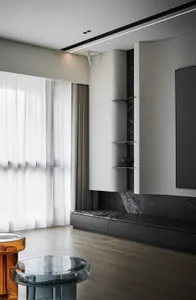 Modern living room featuring a sleek, minimalist design with marble cabinetry and glass stools.