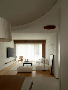 A modern living room featuring neutral-toned furniture and materials, with a minimalist design aesthetic.