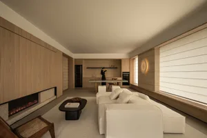 A modern living room with wooden walls, a fireplace, and a comfortable seating area.