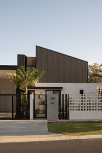 Modern residential building featuring wooden panels and concrete construction.