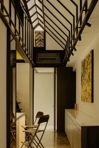 A minimalist industrial entryway with metal, wood, and concrete materials.