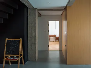 以當代工業風格呈現的室內設計，搭配混凝土牆面、木質地板與玻璃窗。