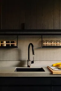 A modern kitchen with concrete tiles and wood paneling