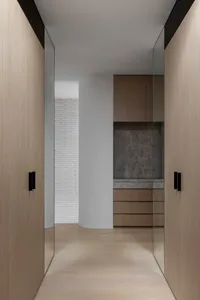 Modern minimalist corridor featuring wooden panels and a concrete wall, designed for residential or commercial spaces.