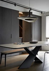 Modern minimalist dining room with a sleek wooden table, metal legs, and minimalist pendant light.