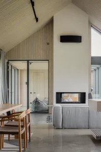 A modern minimalist living room featuring concrete and wood materials.
