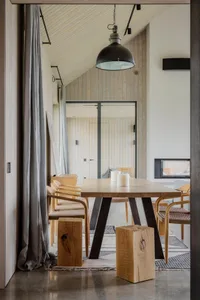 Modern and minimalist residential kitchen with wooden elements and a table.