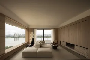 A minimalist residential living room with a large window overlooking a serene river view, featuring a beige modular sofa, a g