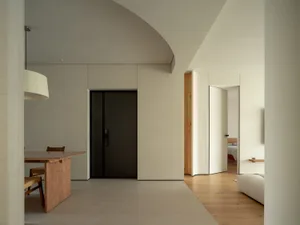 A modern interior with light wood floors, minimalist design, and a white ceiling.