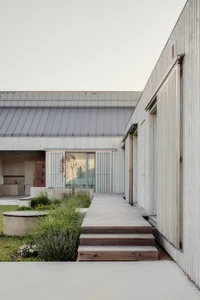 Modern residential exterior featuring wood and concrete materials