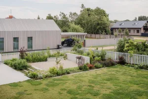 Modern residential exterior with wooden panels and metal roof and fence.