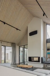 A modern living room featuring wood and concrete materials with a fireplace and seating area.