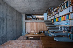 An image depicting a modern office space featuring a concrete bookshelf and a wooden desk with a laptop.