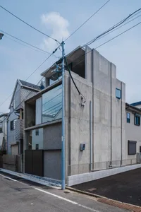 A minimalist, modern building constructed primarily of concrete, featuring clean lines and a sleek design.