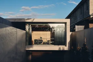 A modern minimalist living room with a concrete floor and terrazzo elements.