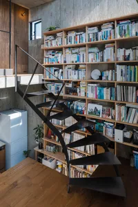 A modern interior design featuring a black staircase with an open railing, set against a background of wooden shelving filled