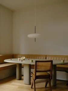 簡約風格的廚房，配有綠色餐桌、棕色餐椅以及吊燈燈具。