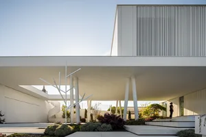 A minimalist, modern building with concrete elements and a playground.