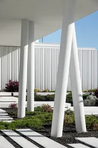 A modern architectural design featuring concrete columns and a pathway beneath them.