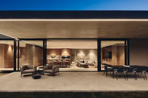 A modern concrete living area with sleek furniture and large windows.