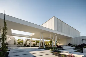 A modern building with a concrete exterior featuring geometric shapes and open spaces.