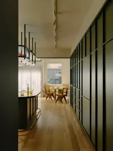 Modern interior with glass windows, wooden flooring, and metal railings.