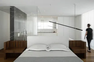 modern minimalist bedroom with white walls, wood headboard, and marble accents