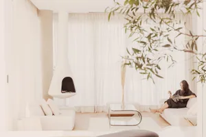 A modern minimalist living room featuring white materials and furniture.