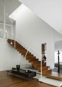 Modern wooden staircase with white railings in an interior setting.