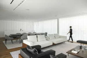 Contemporary living room with grey sofas, black accent chairs, and textured fabrics and wood