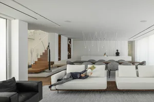 A modern white sofa in a minimalist living room setting.