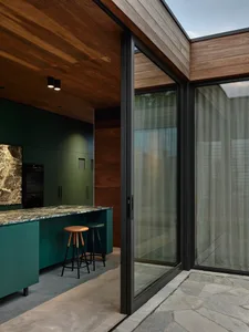 A modern kitchen interior featuring green concrete cabinets and countertops.