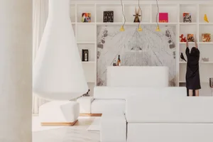 A modern living room with white furniture and a white wall