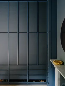 A modern minimalist closet with dark blue sliding panels and integrated storage.