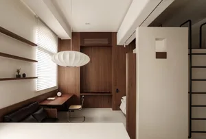 A modern minimalist kitchen with white concrete and wooden surfaces, a minimalist pendant light, and a built-in bench seating