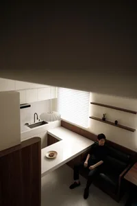 Modern minimalist kitchen with white countertops and wooden accents.