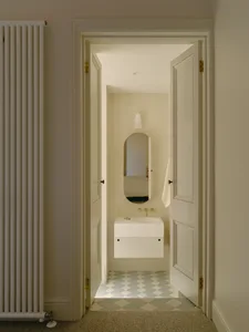 A minimalist bathroom with ceramic tile flooring and white wall tiles.
