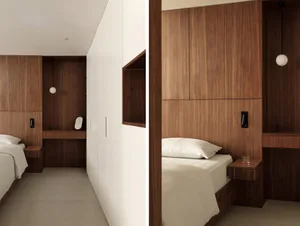 Modern minimalist bedroom with floating nightstands and wood paneling.