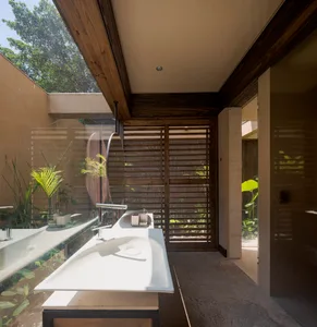 A modern bathroom featuring a sleek, white floating sink with a concrete countertop, situated in a contemporary residential s