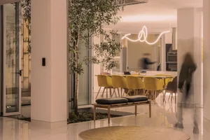 A modern dining room featuring metallic lamp and green plant