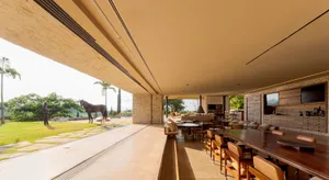 A modern living room featuring contemporary furniture with a minimalist design, concrete flooring, and leather accents.