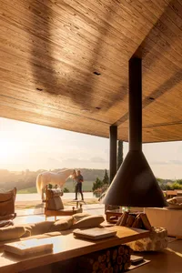 Modern living room featuring wood, concrete, and metal materials with a view of the outdoors.