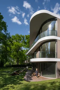 Modern house with curved glass and wooden exterior.