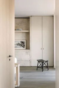 A minimalist apartment featuring concrete shelving and wooden furniture.