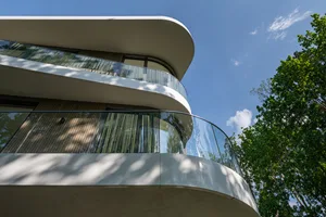 Modern building with curved glass balconies.